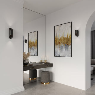 Two black wall lamps mounted symmetrically on white walls flanking a mirror and abstract artwork.