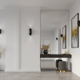 Pair of black wall lamps mounted on white panelled walls in a contemporary hallway setting.