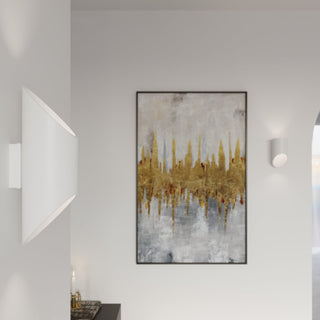 White cylindrical lamp next to artwork in a modern setting, contrasted by a large angled wall light.