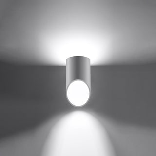 White cylindrical lamp mounted on a surface, emitting light both upwards and downwards.