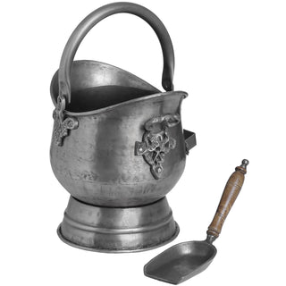 Full view of the antique pewter coal bucket and separate wooden-handled shovel, showing the hammered finish and ornate vine detailing.