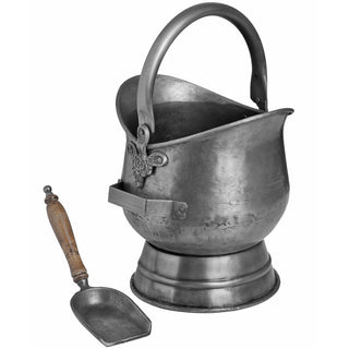 Antique pewter coal bucket showing the bail handle and pedestal base, with the separate wooden-handled shovel.