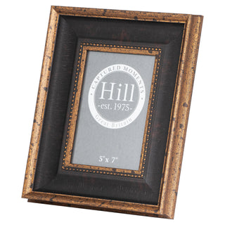 Angled view of a black and distressed gold photo frame with a beaded inner border.