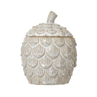 Full front view of the pine cone shaped ceramic jar, glazed white over a beige base.
