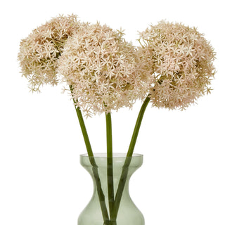 Three artificial pink allium stems arranged in a pale green vase.