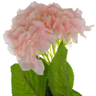 Close-up detail of the artificial pink hydrangea flower head and textured green leaves.