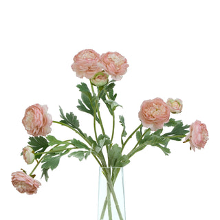 Multiple artificial pink ranunculus stems with flowers and buds arranged in a clear glass vase.