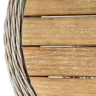Extreme close-up of the table top, showing the texture of the light wood slats and the grey woven wicker edge.