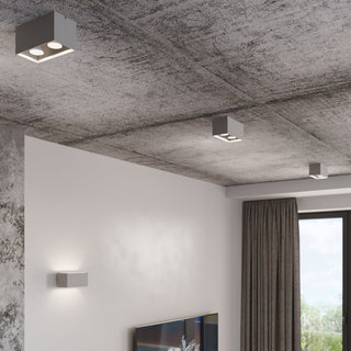Three ceiling lamps and a matching wall light fixture installed in a modern room with a concrete ceiling.