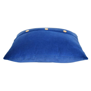 Low-angle view of the royal blue velvet cushion showing its profile and three wooden buttons along the top closure flap.