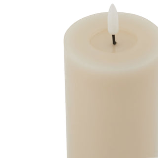 Close-up detail of the cream LED pillar candle top, showing the melted wax effect and the faux flame mechanism.