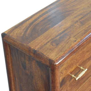 Close-up of the chest's rich wood grain and the textured brass bar handle on the top drawer.