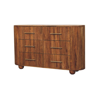 Three-quarter view of the amber oak chest showing the rounded sides and spherical feet.