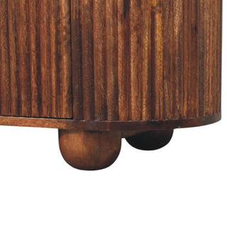 Detail showing the spherical wooden feet and the ridged wood texture at the chest base.
