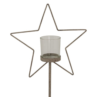 Weathered metal star frame and clear glass votive cup on the supporting stem.