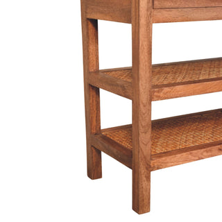 Detail shot of the console's wooden legs and the two lower shelves featuring woven rattan inlay.