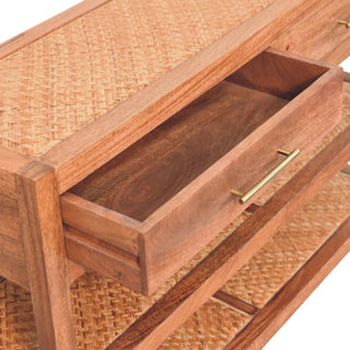 Close detail of the console table drawer pulled open, showing the wooden construction and rattan inlay on the surfaces.