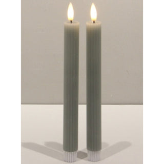 Two sage ribbed taper candles with illuminated tips and white bases, displayed front-on.