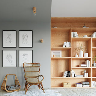 Three natural wood lamp bases used as ceiling, wall, and shelf lights in a room with a bookcase.