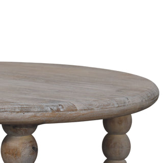 Close-up detail of the distressed salted oak tabletop surface, edge, and the upper section of the turned bobbin legs.