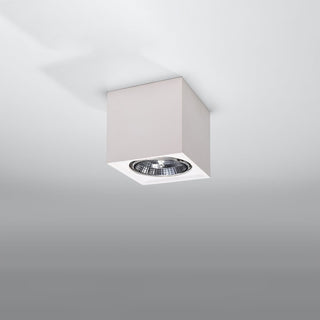 Surface mounted square white ceramic light fixture with a visible recessed halogen spotlight.