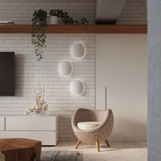 Three white wall lights mounted vertically on a white brick-tiled wall in a modern living space.