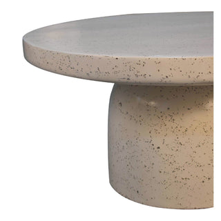 Tight close-up of the coffee table base and tabletop edge, highlighting the speckled beige material.
