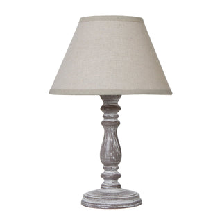 Setia table lamp featuring a turned wooden base with a distressed grey wash finish and a tapered linen shade.