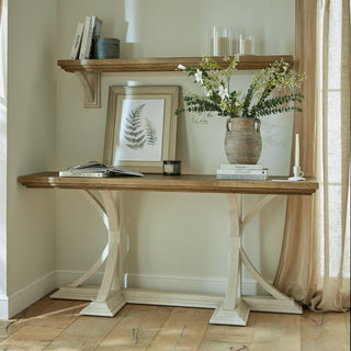 The ceramic amphora pot displayed on a wooden console table with a stack of books and framed artwork.