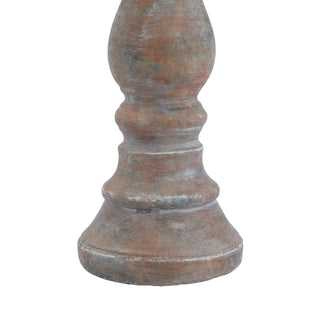 The turned base of the pillar candle holder, highlighting the distressed Siena brown and grey texture.