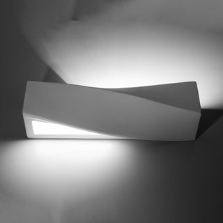 Front view of the white ceramic lamp showing the bright light wash cast onto the wall above and below.