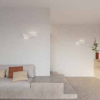 Two ceramic wall lamps installed in a minimalist living space with textured walls and concrete seating.