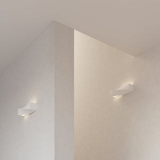 Two lamps illuminating textured walls in a corner, highlighting light colour variation.