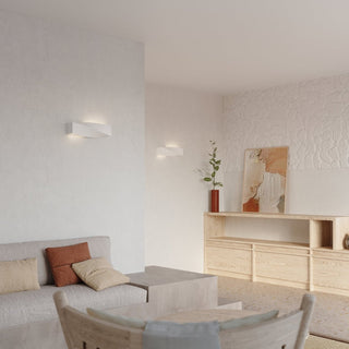 Pair of lamps installed on walls with contrasting smooth and rough white textures in a modern interior.