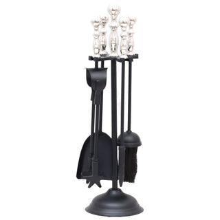 Plain front-on shot of a black metal fireplace tool set on a stand with decorative silver handles.