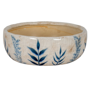 Front view of the small ceramic bowl with a crackled cream glaze and dark blue botanical pattern.