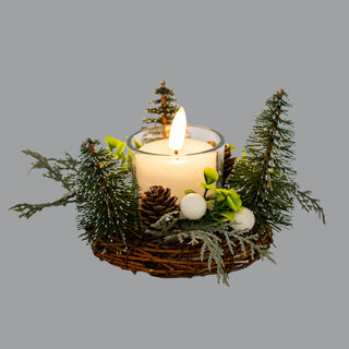 Close view of the festive wreath arrangement showing the LED candle glow, brush trees, pinecones, and frosted foliage.