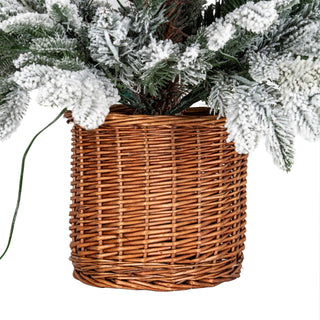 Detail of the brown woven rattan pot base holding the snowy artificial fir tree.