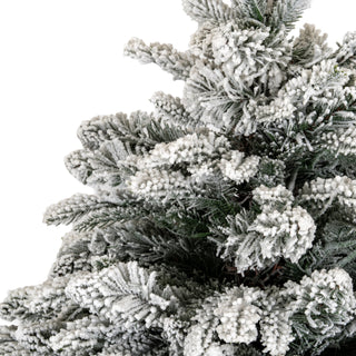 Close-up of the dense, snow-covered branches of the artificial fir tree against a white background.