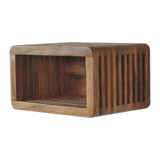 Angled view of the wooden bedside unit highlighting the curved, slatted construction and internal storage shelf.