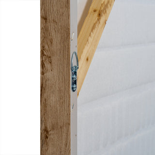 Detail of the canvas frame side showing the metal D-ring hanging fixture and the internal wooden stretcher bar.
