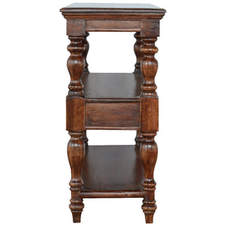End-on view of the solid wood console table showing the depth, turned legs, lower shelf, and drawer section.