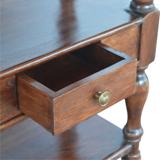 Close-up detail of the dark wood console table showing a drawer pulled open and the brass knob.