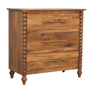 Mango wood three-drawer chest, showing the turned feet and brass bar handles against a white background.