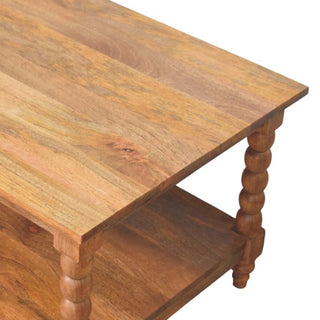 Close-up of the wooden tabletop surface texture and the bobbin turned leg detail at the corner.
