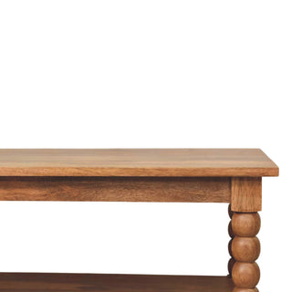Close-up detail of the wooden tabletop edge and the bobbin turned spindle leg structure.