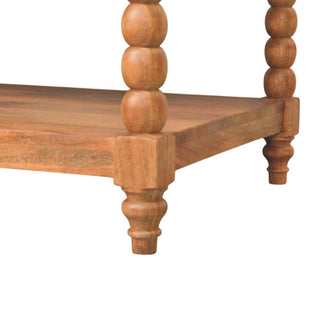 Close-up of the small turned bun feet supporting the lower shelf of the wooden coffee table.