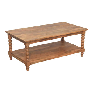 Three-quarter view of the wooden coffee table featuring a rectangular top and full lower shelf on turned legs.