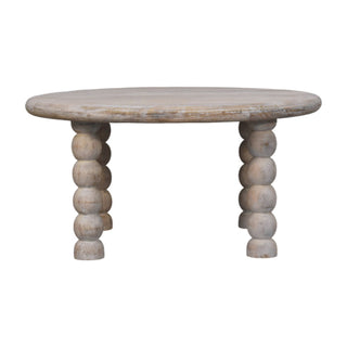 Round salted oak coffee table with bobbin-style spindle legs, isolated on white.