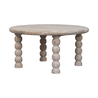 Low angle view of the round salted oak coffee table showing the four turned bobbin legs.